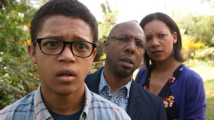 Benny with his parents behind him