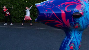 A pair of kids getting blown along by a hairdryer