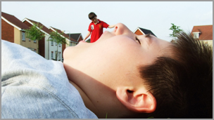 A boy in the foreground laying down with his mouth open with a boy in the background that looks like he's being eaten.