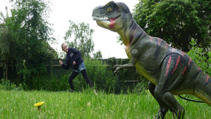 A perspective photo making a toy dinosaur look bigger than a girl