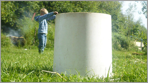 A boy in the background with a tube in the foreground that looks really large.