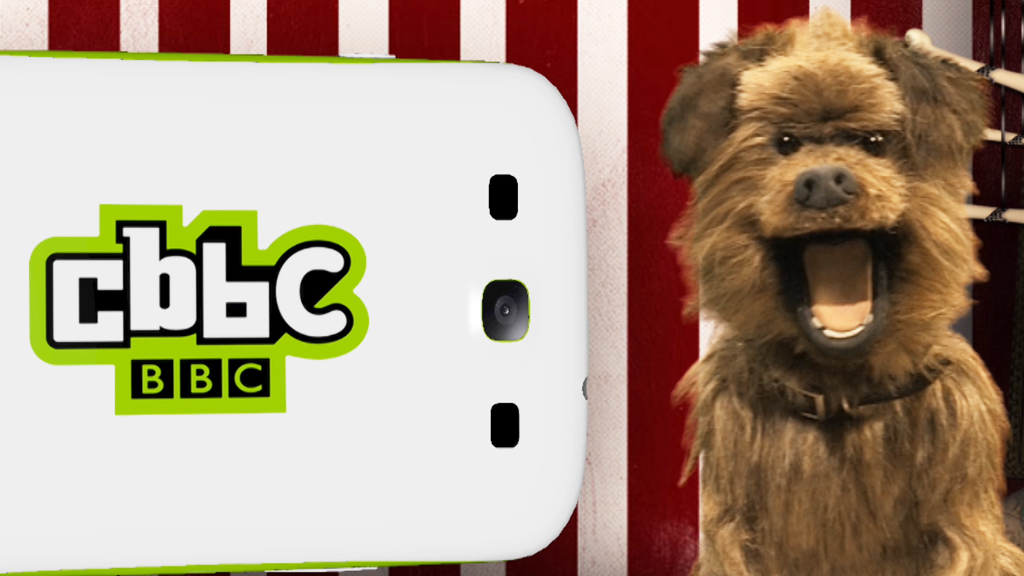 Hacker T Dog next to a CBBC branded mobile phone.