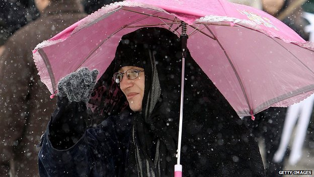 An Iranian woman holds an umbrella
