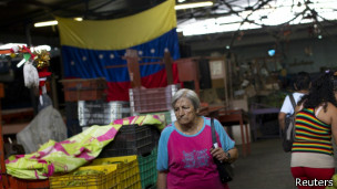 Una mujer camina en un mercado en Venezuela.