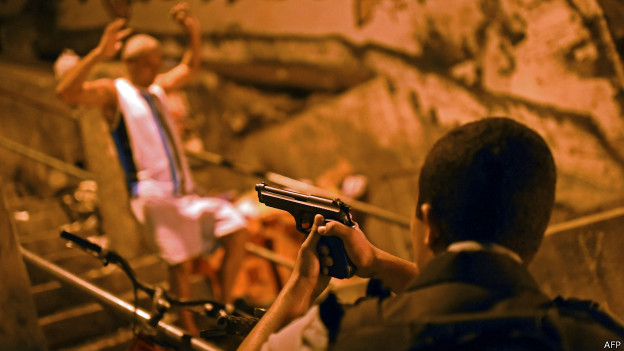 Policial aponta arma para suspeito (foto: AFP)