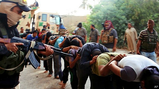 أحد مقاتلي الدولة الإسلامية يرفع السلاح في صف من الأسرى المنحنين